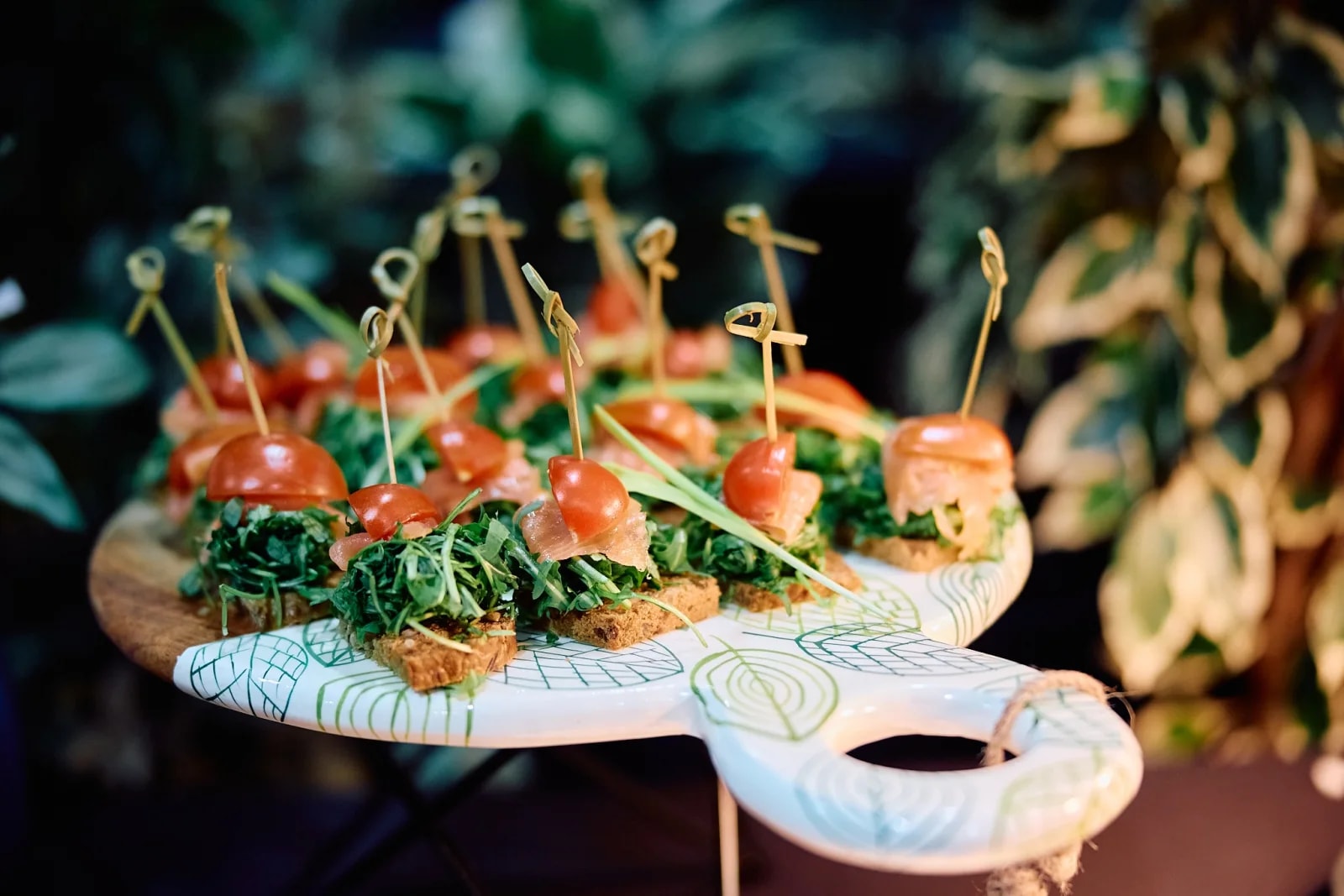 Канапеи са лососом и руколом на дасци за сервирање