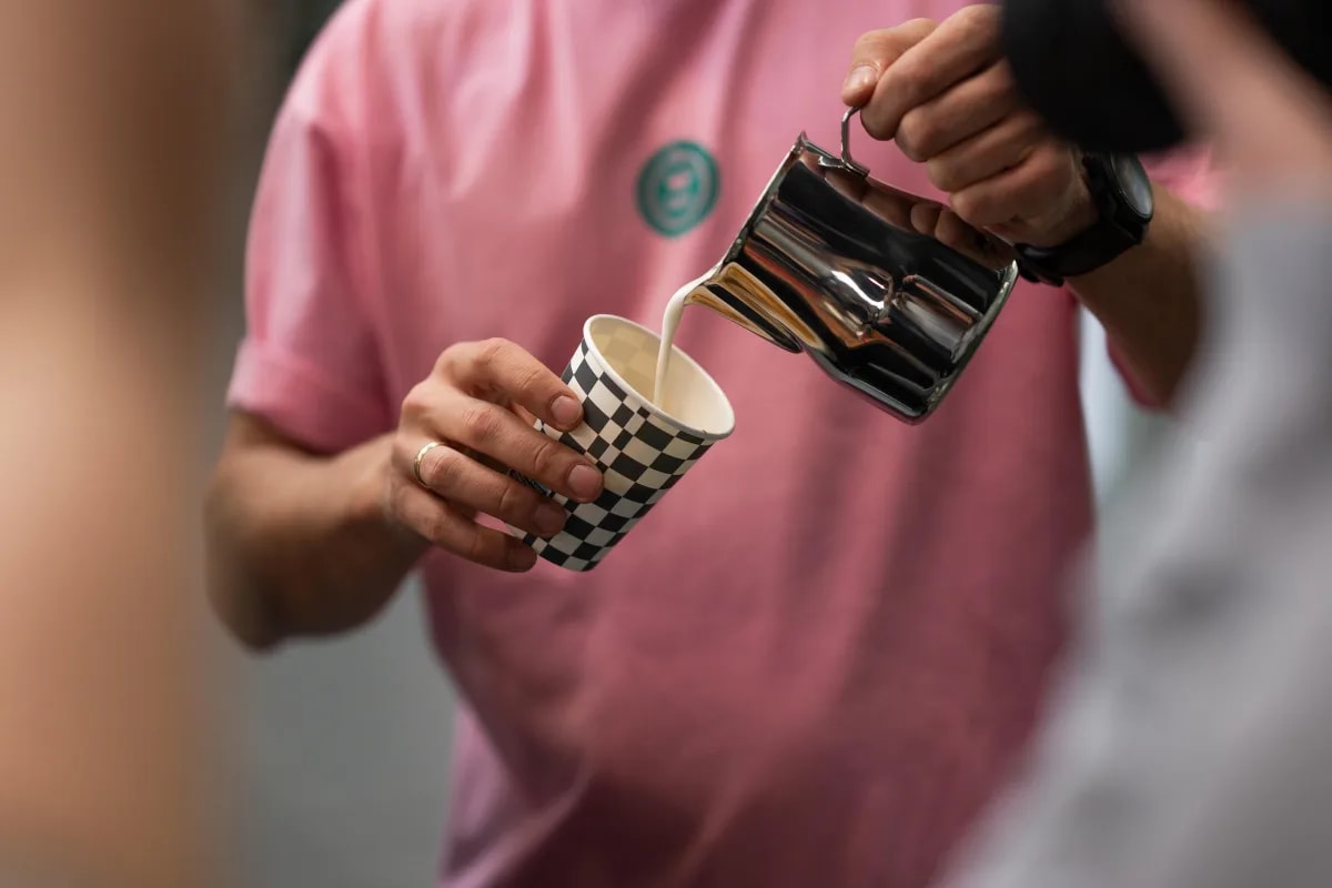 Бариста сипа млеко у кафу на Кафетерија coffee station-у